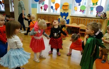 Sala zabaw-na pierwszym planie grupka dzieci w strojach postaci z bajek. W tle kolorowe balony.
