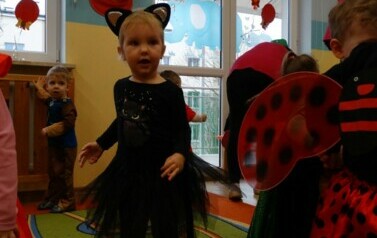 Sala zabaw-na pierwszym planie dziewczynka w przebraniu kota. W tle kolorowe balony.