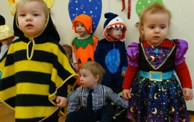 Sala zabaw-na pierwszym planie grupka dzieci w strojach postaci z bajek. W tle kolorowe balony.