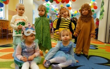 Sala zabaw-na pierwszym planie grupka dzieci w strojach postaci z bajek. W tle kolorowe balony.
