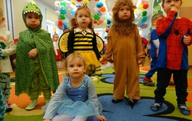 Sala zabaw-na pierwszym planie grupka dzieci w strojach postaci z bajek. W tle kolorowe balony.