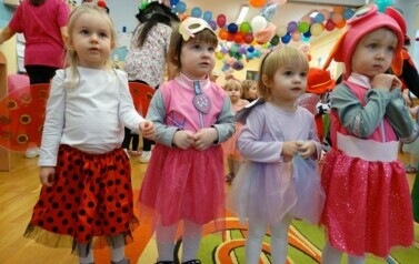 Sala zabaw-na pierwszym planie grupka dziewczynek w strojach postaci z bajek. W tle kolorowe balony.