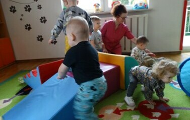 Sala zabaw-na podłodze leżą duże kolorowe piankowe klocki a po nich chodzą dzieci.